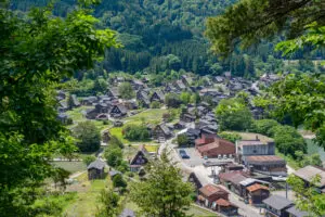 The scenic village of Shirakawa-go is nestled in lush green mountains, featuring traditional gassho-zukuri houses and peaceful countryside life. Japan
