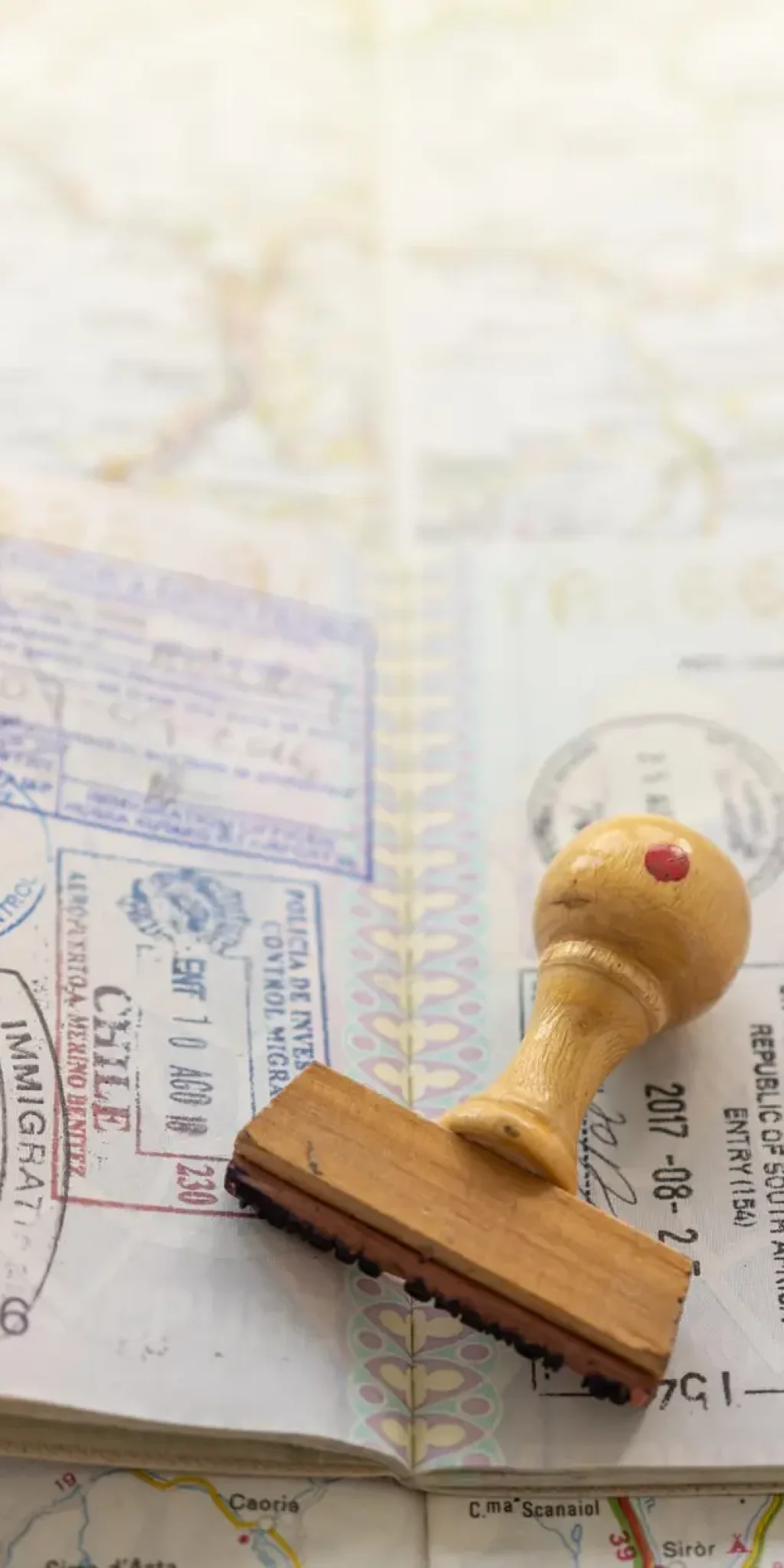 Italian passport pages with a lot of visa stamps on a map.